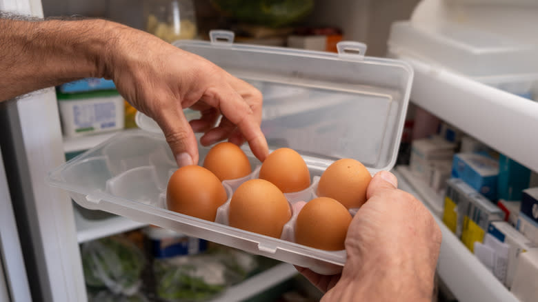 person removing eggs from cartons