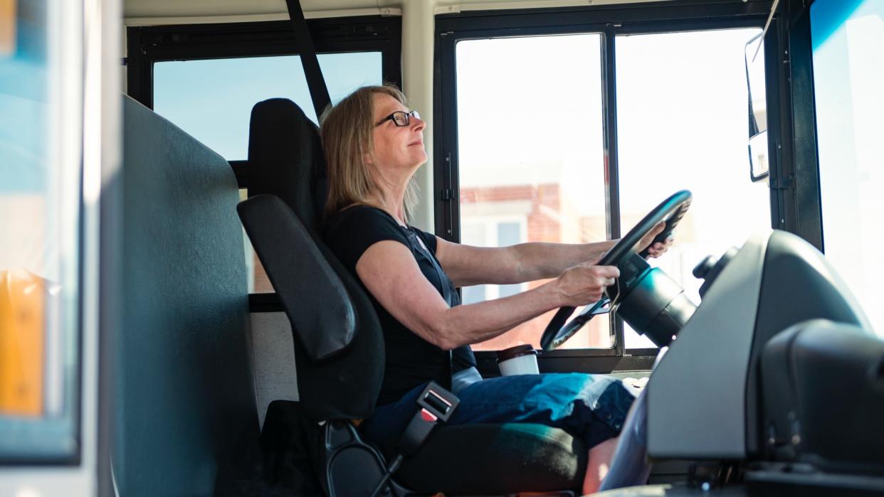 Portrait of mature woman driving a school bus.