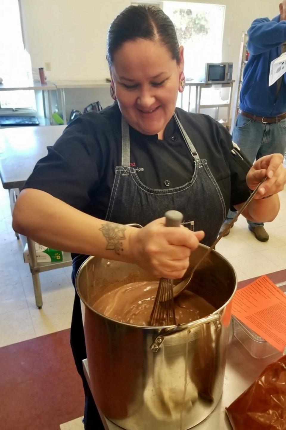 Elena Terry, executive chef and founder of Wild Bearies, an outreach and catering nonprofit centering Native foods, stirs a pot. Terry said she is seeing more of her Native American friends opening restaurants and catering businesses to celebrate their food culture.