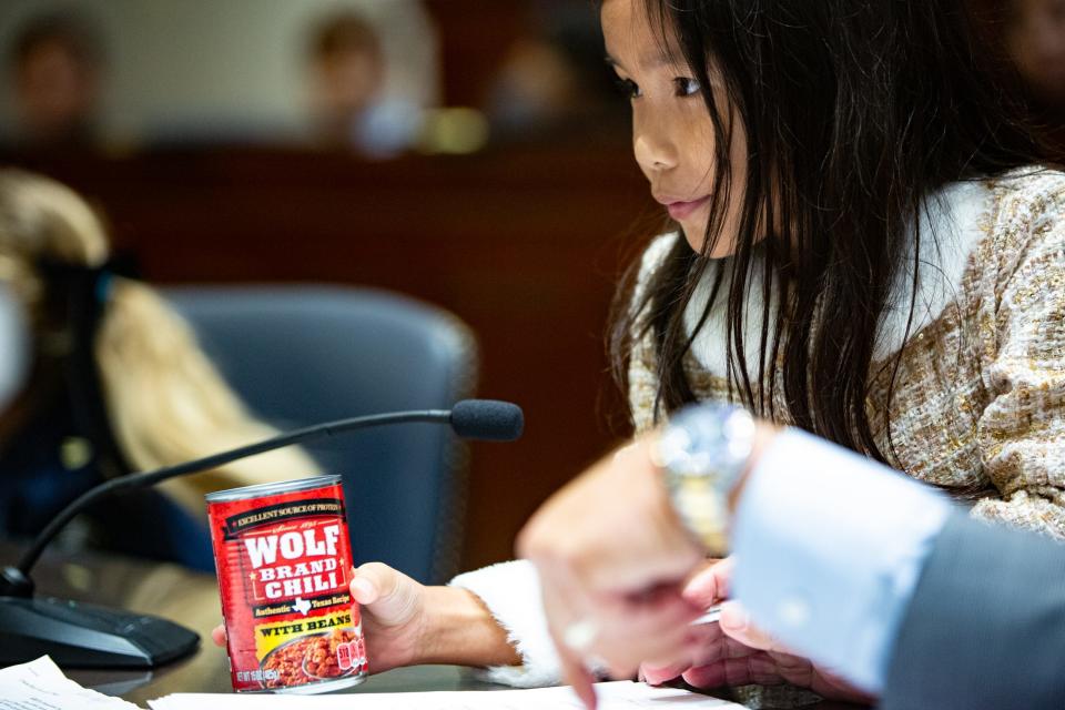 Flour Bluff student Brianna Meng, portraying a Big Bad Wolf defense lawyer, presents a can of Wolf Brand Chili as evidence that The Three Little Pigs planned to eat the wolf during a mock trial at the Federal Courthouse on Thursday, Nov. 16, 2023, in Corpus Christi, Texas.