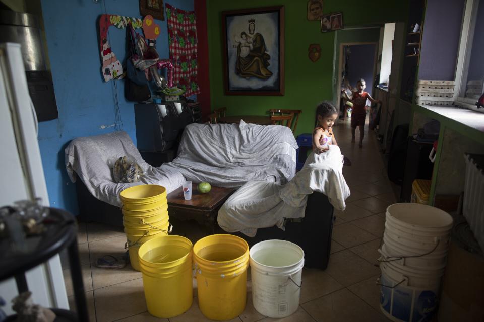 Buckets, some of them filled with water provided by a government tanker truck, are stored in the living room of a house in the Petare neighborhood of Caracas, Venezuela, Monday, June 15, 2020. Venezuela's economic collapse has left most homes without reliable running water. (AP Photo/Ariana Cubillos)