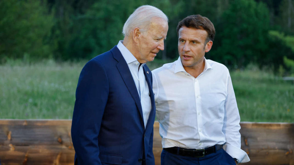 Le président américain Joe Biden (G) et le président français Emmanuel Macron parlent après avoir posé pour une photo de groupe informelle sur un banc après un dîner de travail lors du sommet du G7 qui se tient au château d’Elmau, dans le sud de l’Allemagne, le 26 juin 2022. (Photo de Ludovic MARIN / POOL / AFP)