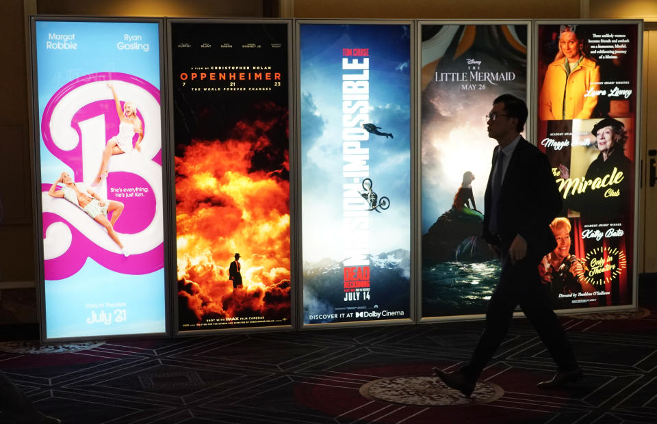 An attendee walks past advertisements for upcoming films on the opening day of CinemaCon 2023, the official convention of the National Association of Theatre Owners (NATO) at Caesars Palace, Monday, April 24, 2023, in Las Vegas. The four-day convention runs through Thursday. (AP Photo/Chris Pizzello)