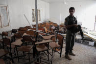 A policeman stands guard in a damaged classroom after a suicide attack in Baghdad’s eastern neighborhood of Ur, Iraq, Sunday, April 20, 2014. A suicide bomber with an explosives belt attacked the main gate of a Shiite private college while three militants attacked the back gate, leaving several people dead and over a dozen people were wounded. Security forces killed all of the attackers. (AP Photo/Khalid Mohammed)