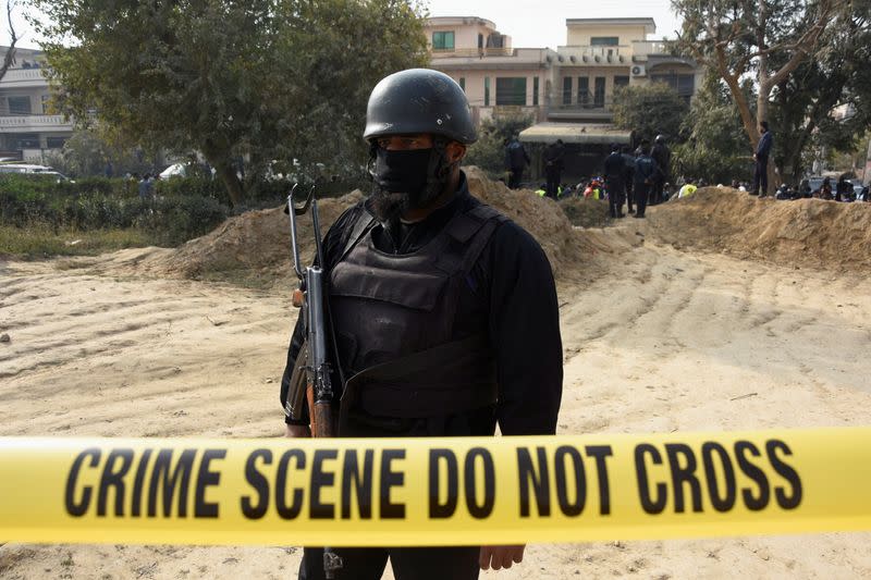 A police officer stands inside cordoned-off area after a suicide car bombing in Islamabad