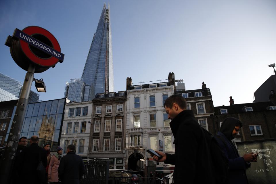 Commuters use the London underground, Wednesday, Dec. 11, 2019, backdropped by The Shard building. Britain will go to the polls tomorrow Dec. 12, to vote in a pre-Christmas general election. (AP Photo/Thanassis Stavrakis)