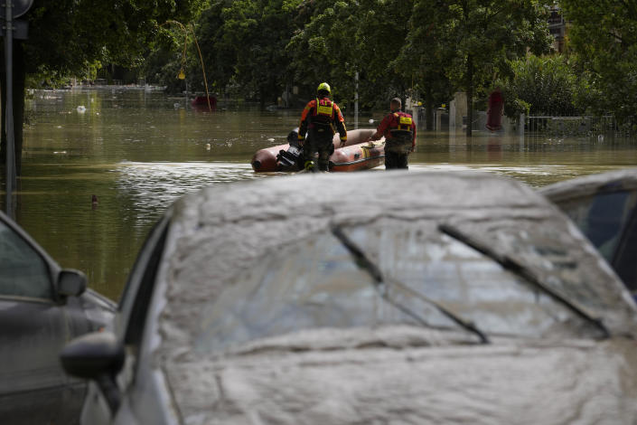 Rescuers use a dinghy on flooded road in Faenza, Italy, Thursday, May 18, 2023. Exceptional rains Wednesday in a drought-struck region of northern Italy swelled rivers over their banks, killing at least eight people, forcing the evacuation of thousands and prompting officials to warn that Italy needs a national plan to combat climate change-induced flooding. (AP Photo/Luca Bruno)