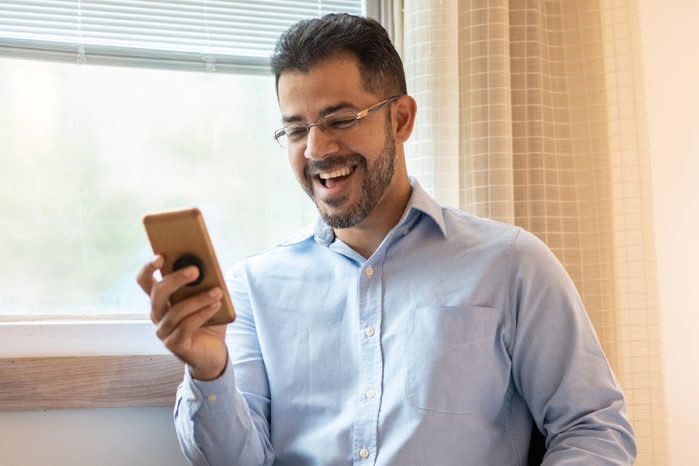 man laughing at his phone because the ringtone was changed for april fools day