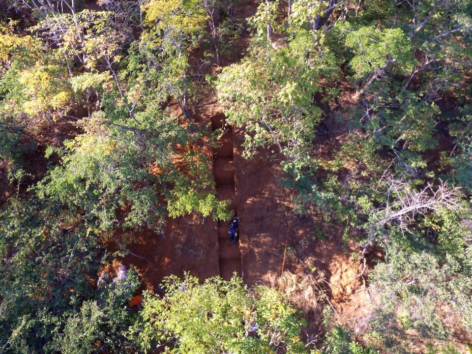 Open woodlands have grown over alluvial fans that formed during the Middle Stone Age. Trenches such as this one at an excavation site show multiple layers of discarded artifacts over a period of tens of thousands of years. Jessica Thompson, <a href="http://creativecommons.org/licenses/by-nd/4.0/" rel="nofollow noopener" target="_blank" data-ylk="slk:CC BY-ND;elm:context_link;itc:0;sec:content-canvas" class="link ">CC BY-ND</a>