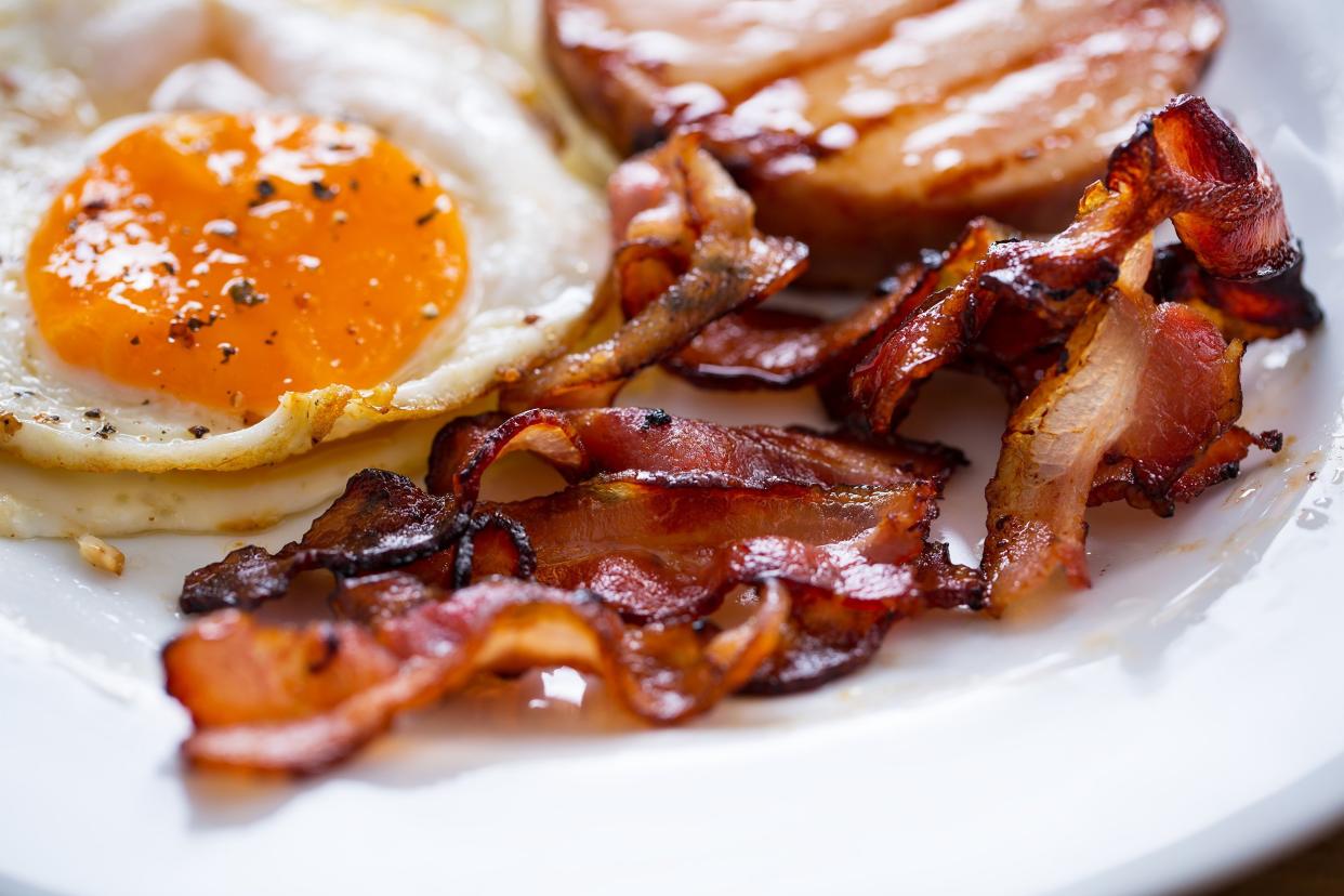 bacon, egg, and ham for breakfast in plate