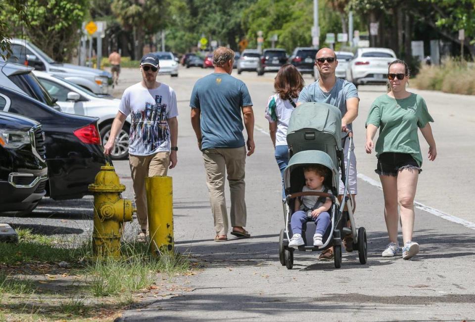 Jean-Paul Behrens and Paula Behrens pushed son Elias Behrens in his baby carriage on the popular Commodore Trail along South Bayshore Drive in Miami’s Coconut Grove in 2022. Miami-Dade County is working on a $16 million plan to rebuild a 1.5-mile stretch of Bayshore and the trail. Critics say poor design, deteriorating conditions and speeding traffic pose a hazard for trail users.