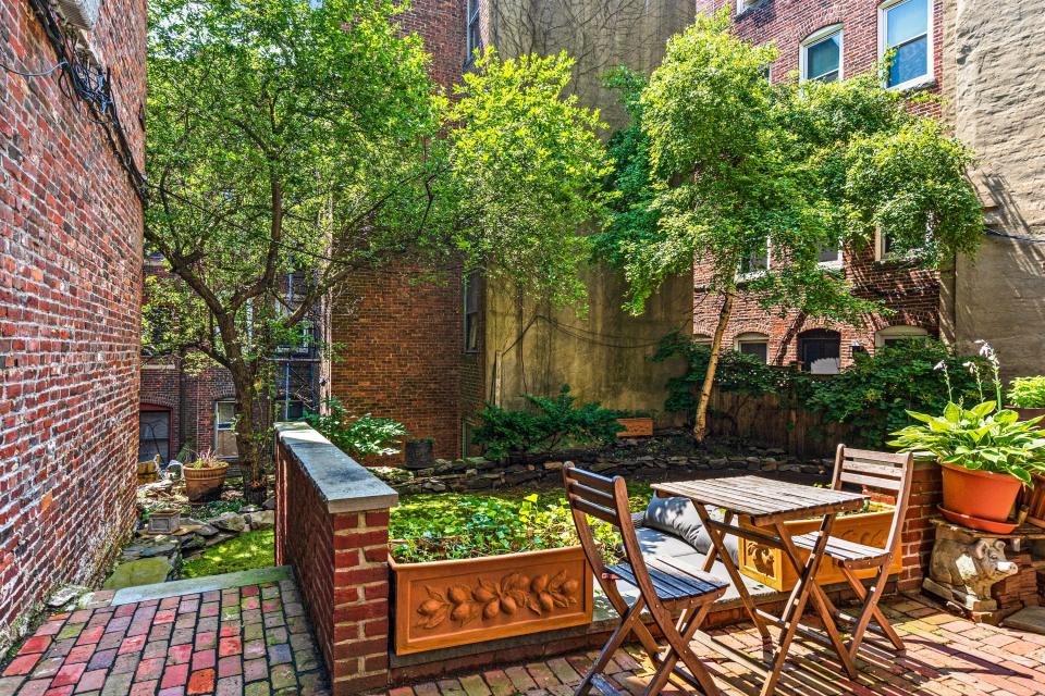 A courtyard outside of the home with trees and seating areas