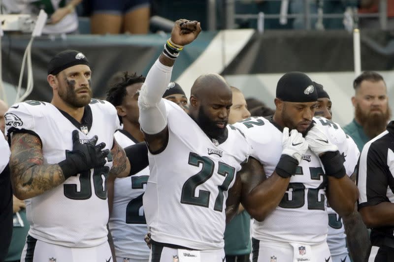 Chris long, left, stands in support of Malcom Jenkins during his social protest. (AP)