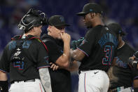 Miami Marlins pitching coach Mel Stottlemyre, center talks to relief pitcher Huascar Brazoban (31) after the Washington Nationals scored two runs during the eight inning of a baseball game, Thursday, May 18, 2023, in Miami. (AP Photo/Marta Lavandier)