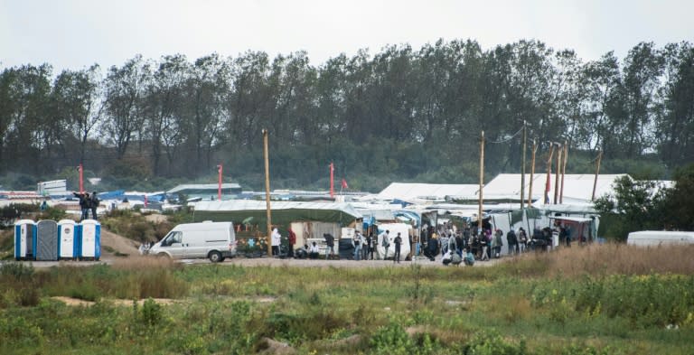 Migrants and refugees gather at the entrance of the 'Jungle' migrant camp in Calais, northern France