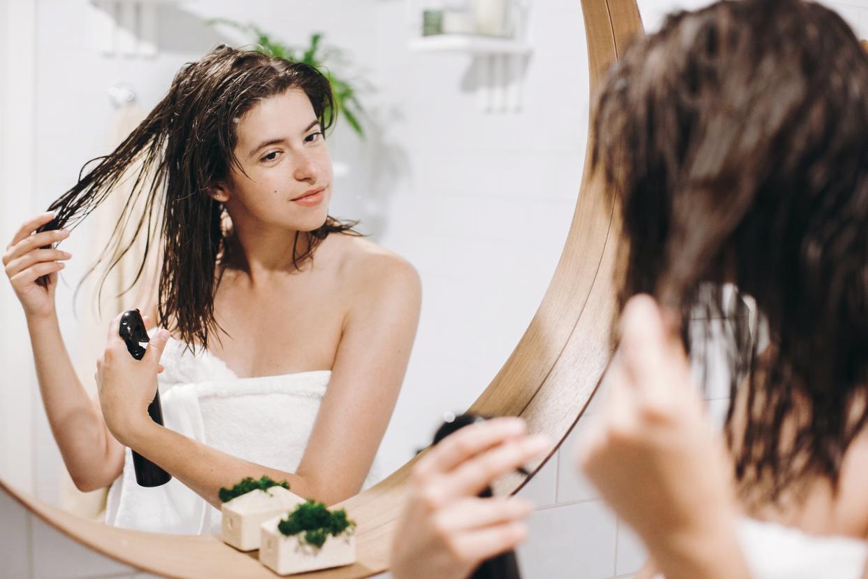 woman applying leave-in conditioner on hair