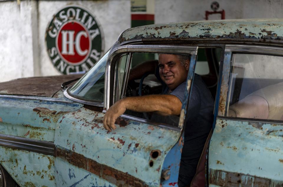 Julio Alvarez, co-owner of Nostalgicar, poses inside his latest classic American car acquisition that he hopes to restore in Havana, Cuba, Wednesday, Oct. 21, 2020. Alvarez and his business partner met with influential Republican Cuban American lawmakers during a 2017 trip to Washington in which they advocated for U.S.-Cuba relations to continue. (AP Photo/Ramon Espinosa)