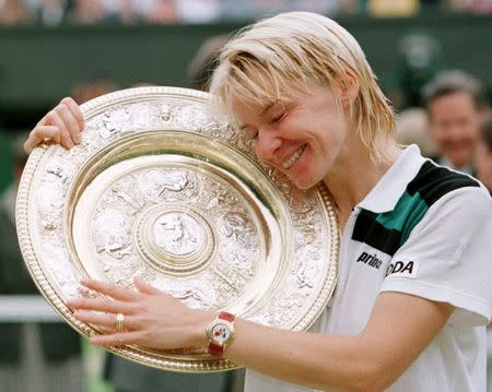 FILE PHOTO - Jana Novotna of the Czech Republic hugs the winner's trophy after victory over Nathalie Tauziat of France in the Women's Singles final at the Wimbledon Tennis Championships July 4. Novotna won the match 6-4 7-6 (7-2)/File Photo