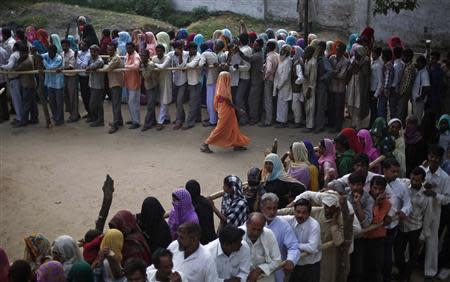 A woman leaves after casting her as others wait in a queue at a polling station in Shabazpur Dor village, in Amroha district in the northern Indian state of Uttar Pradesh April 17, 2014. REUTERS/Adnan Abidi