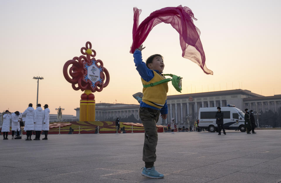 A child plays with a red scarf near a decoration for the Beijing Winter Olympics Games in front of the Great Hall of the People on Tiananmen Square in Beijing on Jan. 18, 2022. The just-concluded Winter Olympics weren’t China's big event of the year, internally, at least. For the Communist Party, that comes this fall at a major meeting that will likely cement Xi Jinping's position as one of the nation's most powerful leaders in its seven decades of Communist rule. (AP Photo/Ng Han Guan)