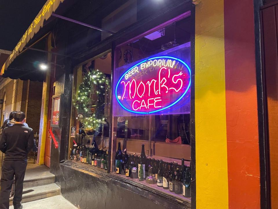 exterior of monk's cafe in philly, neon sign out front