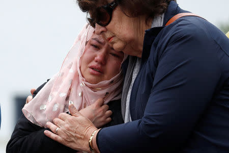 People embrace as they pay respects after Friday's shooting, outside the Masjid Al Noor in Christchurch, New Zealand March 18, 2019. REUTERS/Jorge Silva