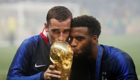 Soccer Football - World Cup - Final - France v Croatia - Luzhniki Stadium, Moscow, Russia - July 15, 2018 France's Antoine Griezmann and Thomas Lemar kiss the trophy as they celebrate winning the World Cup REUTERS/Carl Recine