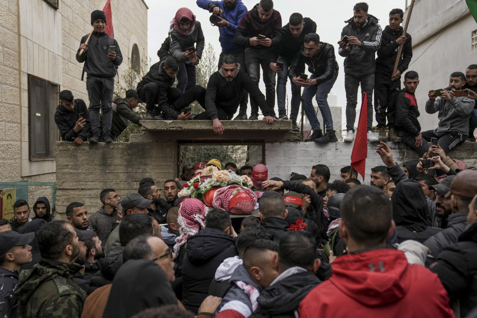 Mourners carry the body of 14-year-old Palestinian Omar Khumour during his funeral in the West Bank city of Bethlehem, Monday, Jan. 16, 2023. The Palestinian Health Ministry said Khumour died after being struck in the head by a bullet during an Israeli military raid into Dheisha refugee camp near the city of Bethlehem. The Israeli army said that forces entered the Dheisha camp and were bombarded by Molotov cocktails and rocks. It said soldiers responded to the onslaught with live fire. (AP Photo/Mahmoud Illean)