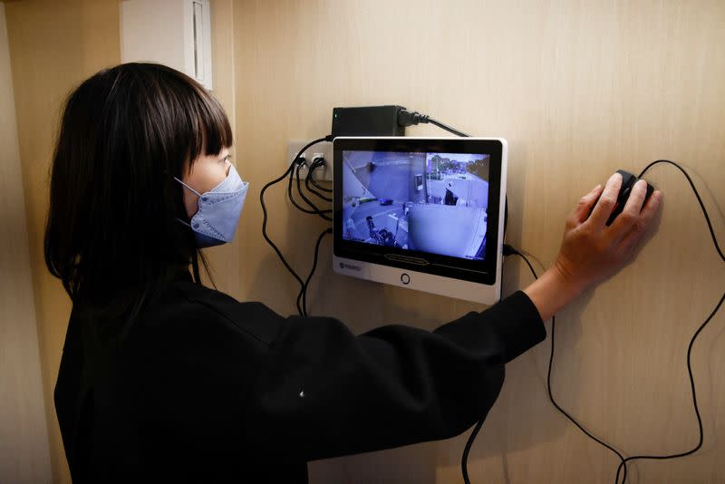 Megumi Morohoshi, a Japanese mother of three, demonstrates the external surveillance system of her family's newly installed bomb shelter in Saitama