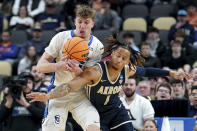 Creighton's Baylor Scheierman reaches for a loose ball against Akron's Shammah Scott during the first half of a first-round college basketball game in the NCAA Tournament, Thursday, March 21, 2024, in Pittsburgh. (AP Photo/Matt Freed)