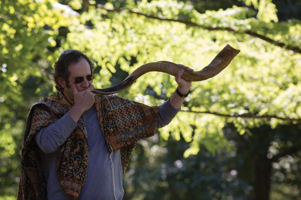 A man blowing a shofar during a Jewish Rosh Hashanah ceremony.