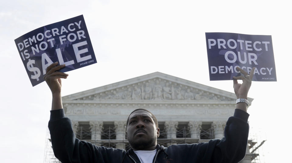 FILE - This Oct. 8, 2013 file photo shows Cornell Woolridge of Windsor Mill, Md., takes part in a demonstration outside the Supreme Court in Washington as the court heard arguments on campaign finance. The Supreme Court struck down limits Wednesday in federal law on the overall campaign contributions the biggest individual donors may make to candidates, political parties and political action committees. The justices said in a 5-4 vote that Americans have a right to give the legal maximum to candidates for Congress and president, as well as to parties and PACs, without worrying that they will violate the law when they bump up against a limit on all contributions, set at $123,200 for 2013 and 2014. That includes a separate $48,600 cap on contributions to candidates. (AP Photo/Susan Walsh, File)