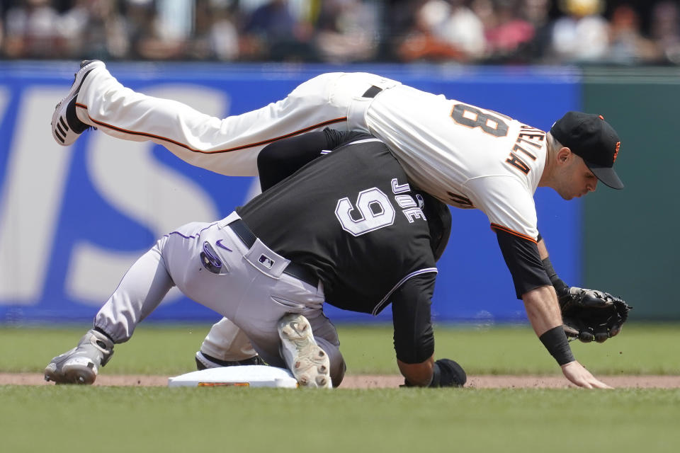 San Francisco Giants second baseman Tommy La Stella, top, falls forward after forcing out Colorado Rockies' Connor Joe (9) at second base during the fourth inning of a baseball game in San Francisco, Sunday, Aug. 15, 2021. (AP Photo/Jeff Chiu)