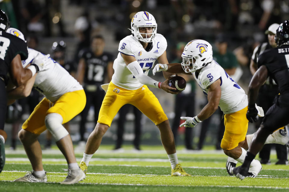 San Jose State corner back Zavion Reese (17) hands the ball to San Jose State running back Kairee Robinson (32) in the first half of a college football game against Hawaii, Saturday, Sept. 18, 2021, in Honolulu. (AP Photo/Marco Garcia)