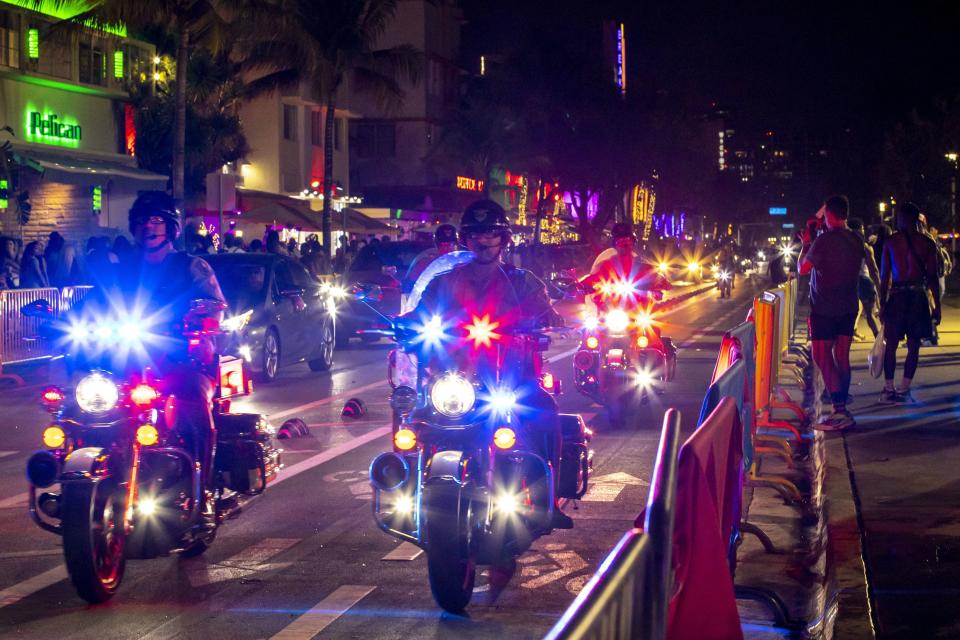 Crowds fill the sidewalks along Ocean Drive as police patrol the streets during Spring Break in Miami Beach, Florida, on Sunday, March 20, 2022.(Daniel A. Varela/Miami Herald via AP)