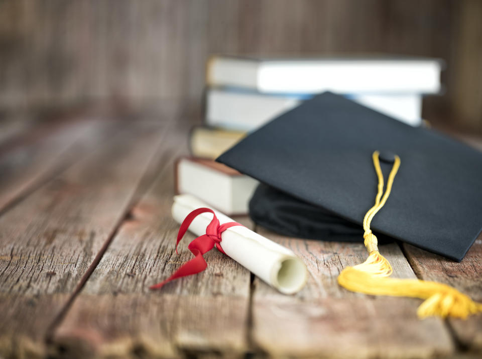 a cap and degree on top of a books