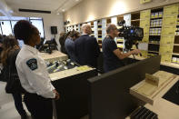 Members of the media attend a preview for one of Quebec's new cannabis stores in Montreal, Tuesday, Oct. 16, 2018. Canada will become the second and largest country with a legal national marijuana marketplace when sales begin on midnight Wednesday. (Ryan Remiorz/The Canadian Press via AP)