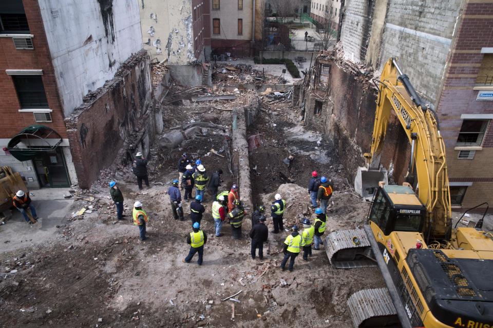 FILE - In this Sunday, March 16, 2014, file photo, workers stand beside the recently cleared basements of two buildings leveled by an explosion last week in the East Harlem neighborhood of New York. A gas main leak has been found at the site of the explosion that killed eight people and leveled two Manhattan buildings, federal investigators said Tuesday, March 18, 2014, but cautioned that they're still a long way from determining what caused the blast. (AP Photo/John Minchillo, File)