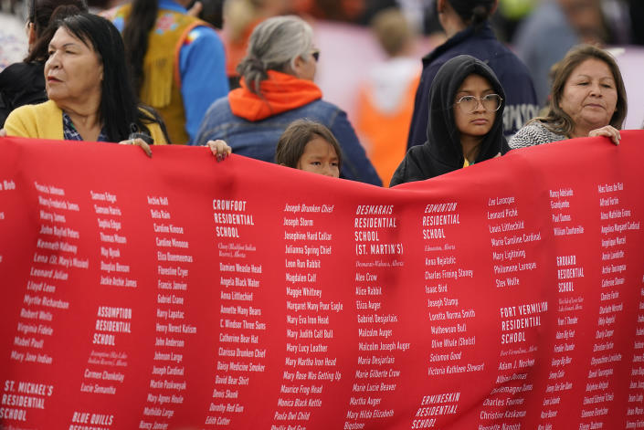 Indigenous people hold up a banner while waiting for Pope Francis during his visit to Maskwaci, the former Ermineskin Residential School, Monday, July 25, 2022, in Maskwacis, Alberta. Pope Francis traveled to Canada to apologize to Indigenous peoples for the abuses committed by Catholic missionaries in the country's notorious residential schools. (AP Photo/Eric Gay)
