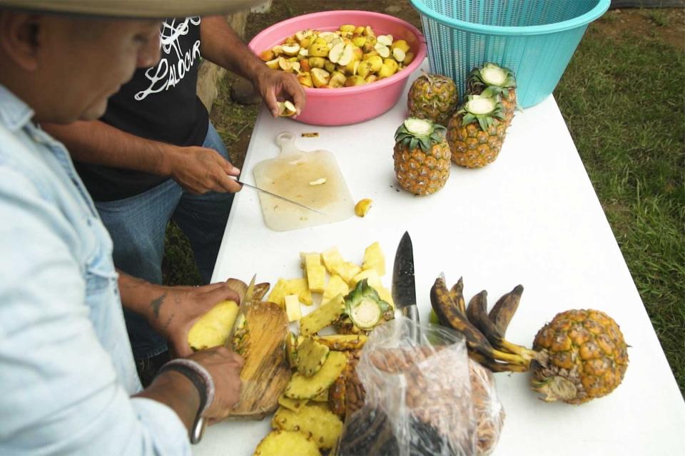 Omar Alonso and Lalo chopping fruit to make mezcal in their episode of Walk With T+L