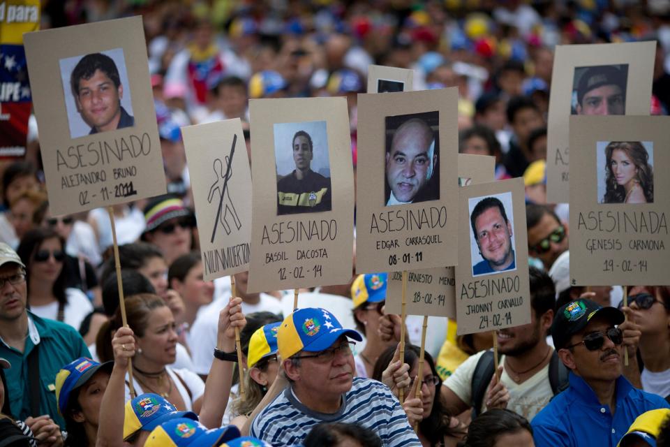 Manifestantes sostienen pancartas con las fotografías de venezolanos que murieron en las protestas de la últimas semanas durante una manifestación opositora en Caracas, Venezuela, el viernes 28 de febrero de 2014. (AP foto/Rodrigo Abd)