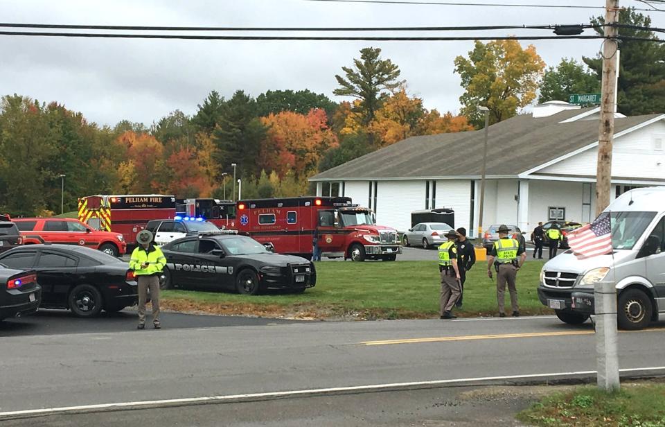 RETRANSMITTED WITH NEW SLUG AND BETTER QUALITY - In this photo provided by WMUR-TV, police stand outside the New England Pentecostal Church after reports of a shooting on Saturday, Oct. 12, 2019, in Pelham, N.H. WMUR-TV reports that Hillsborough County Attorney Michael Conlon said a suspect is in custody. (Siobhan Lopez/WMUR-TV via AP)