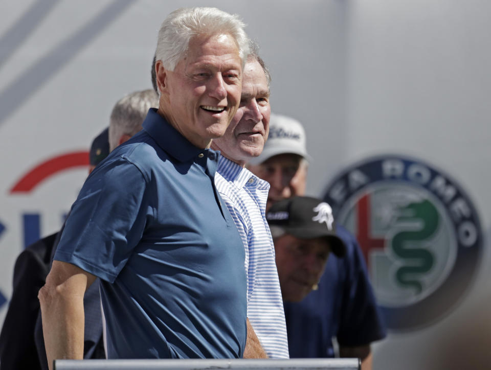 <p>Former Presidents Bill Clinton, front, and George Bush arrive at the first tee before the first round of the Presidents Cup at Liberty National Golf Club in Jersey City, N.J., Sept. 28, 2017. (Photo: Julio Cortez/AP) </p>