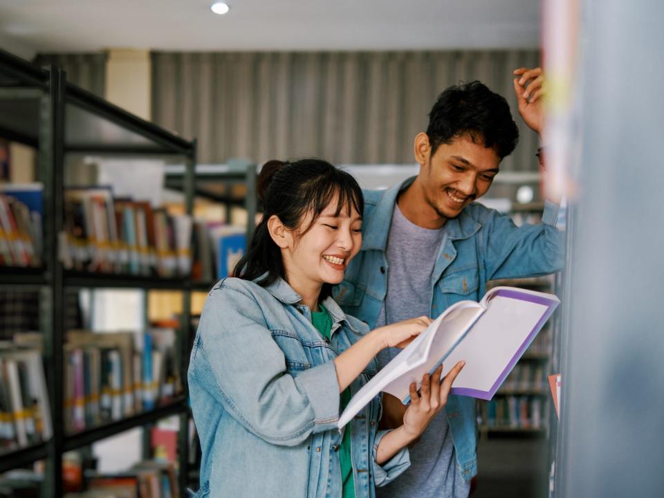 A couple looks at a book in a book store.