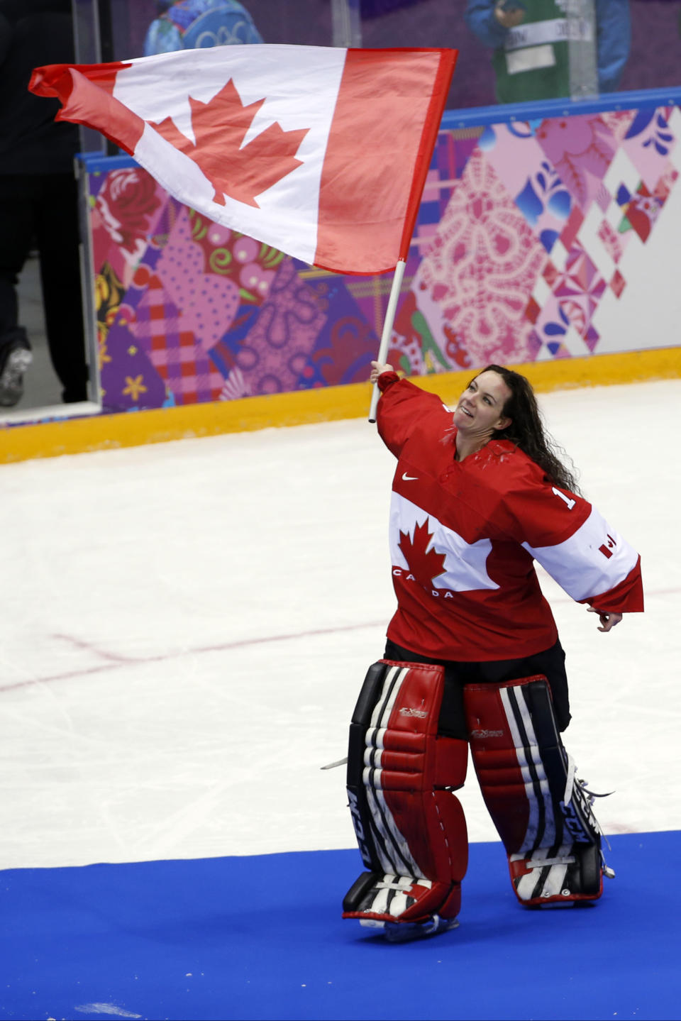 Goalkeeper Shannon Szabados of Canada (1) wave a flag after the women's gold medal ice hockey game against USA at the 2014 Winter Olympics, Thursday, Feb. 20, 2014, in Sochi, Russia. (AP Photo/Petr David Josek)