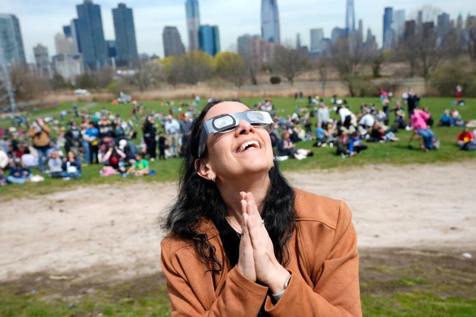 Gili Segall, of Hoboken, watches the eclipse from Liberty Science Center, Monday, April 8, 2024.
