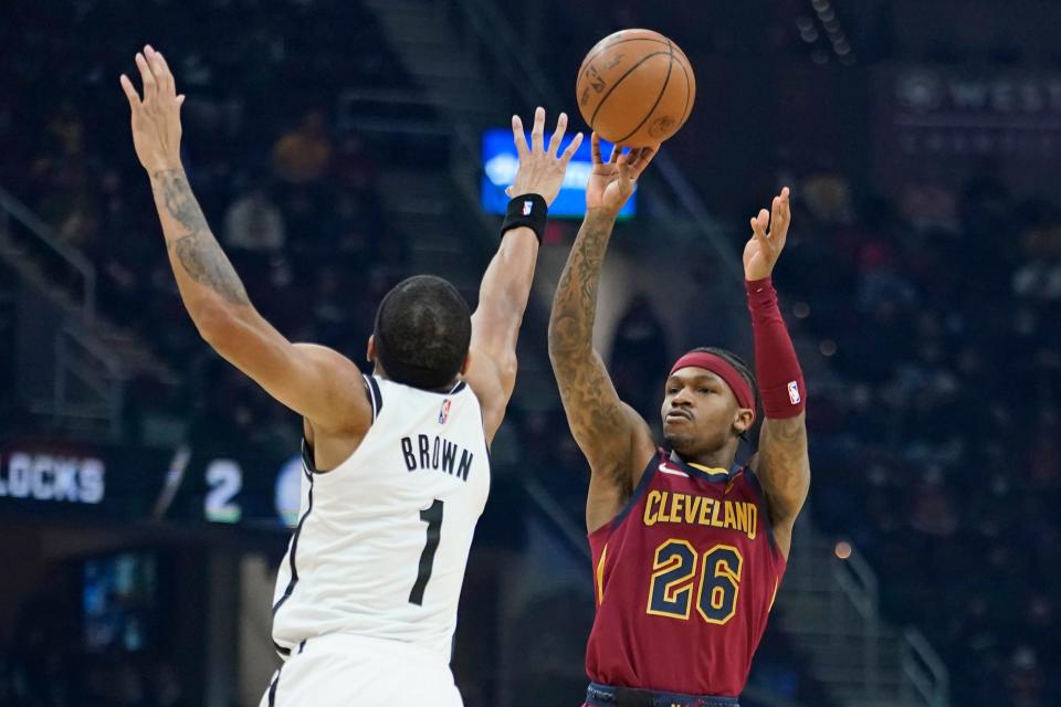 Cleveland Cavaliers' Brandon Goodwin (26) shoots over Brooklyn Nets' Bruce Brown (1) in the first half of an NBA basketball game, Monday, Jan. 17, 2022, in Cleveland. (AP Photo/Tony Dejak)