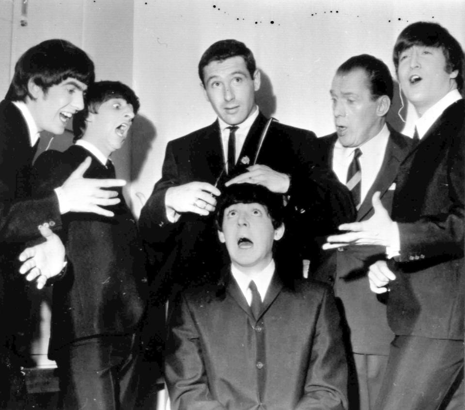 FILE - American speed skating champion Terry McDermott, background center, a barber by trade, prepares to take a swipe at the famed locks of Beatle Paul McCartney, seated , to the mock horror of the other Beatles and TV host Ed Sullivan, during rehearsals at the TV Studio, New York, Feb. 9, 1964. From left, George Harrison, Ringo Starr, McDermott, Ed Sullivan and John Lennon. McDermott, who won the only gold medal for the United States at the 1964 Winter Olympics, died on Saturday, May 20, 2023, U.S. Speedskating said. He was 82. (AP Photo/File)