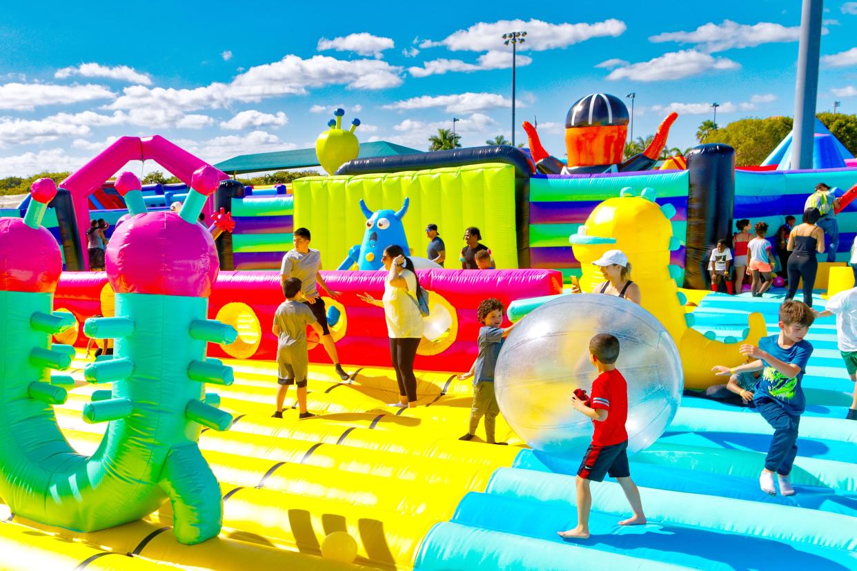 Children and adults play on Sports Slam, one of the giant bounce houses from Big Bounce America coming to Milwaukee Sept. 6-8, 2024.