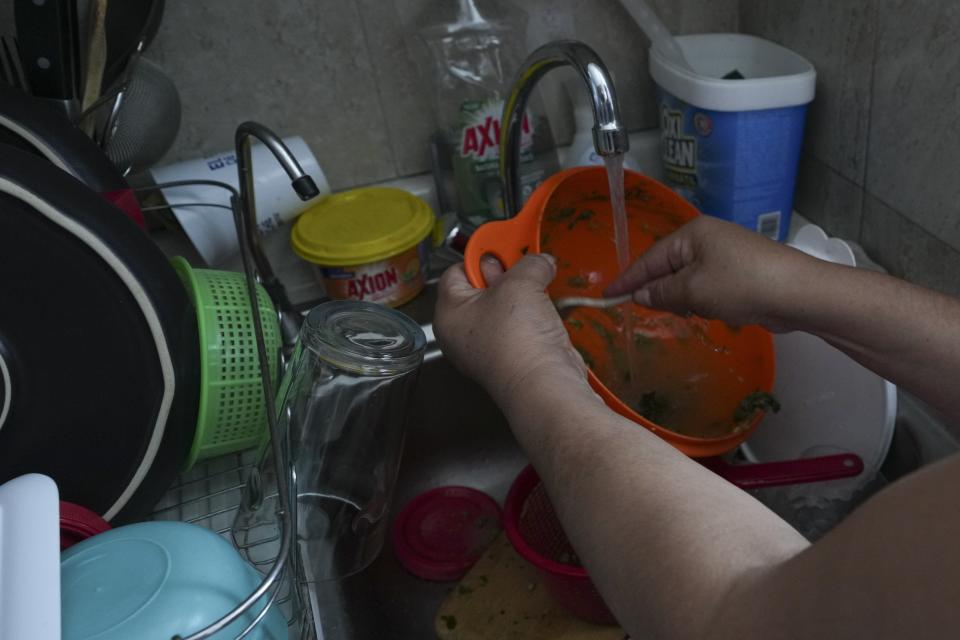 Domestic worker Gabriela Flores washes dishes at her workplace in Mexico City, Sunday, May 19, 2024. Flores is among approximately 2.5 million Mexicans — largely women — who serve as domestic workers in the Latin American nation. (AP Photo/Marco Ugarte)